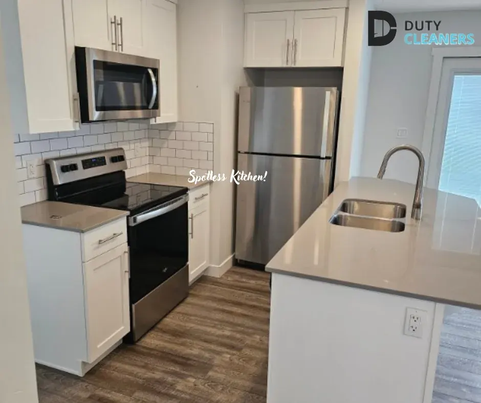 Kitchen with white shaker cabinets, stainless-steel appliances and a quartz island with a double sink
